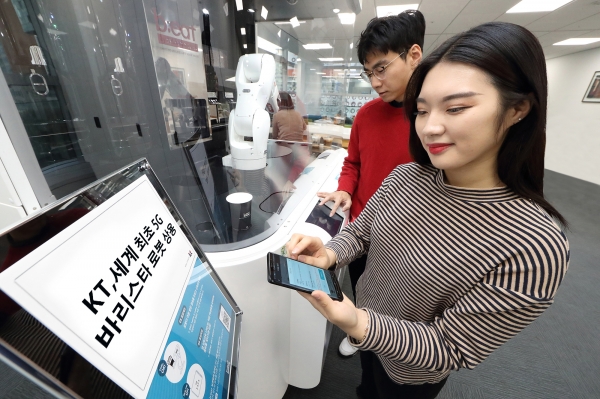 KT 모델들이 세계 최초의 5G 로봇 카페에서 바리스타 로봇이 제조한 커피를 들고 촬영하고 있는 모습. 사진= KT