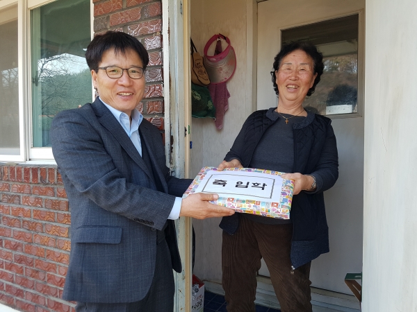김상원 회인면장이 김풍자할머니에게 초등학교 입학선물을 전달한 모습