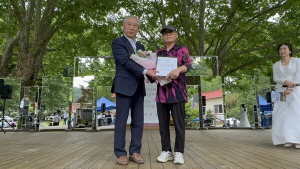 ▲이광순 여사에게 장한어머니상을 황기백 동이면리장협의회장이 전달하고 있다.