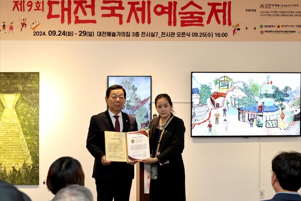 ▲해외작가 대표 태국 쿨차누트 텀프라율 작가에게 감사장과 전시증명서를 수여하고 있다.(사진출처:대전예총)